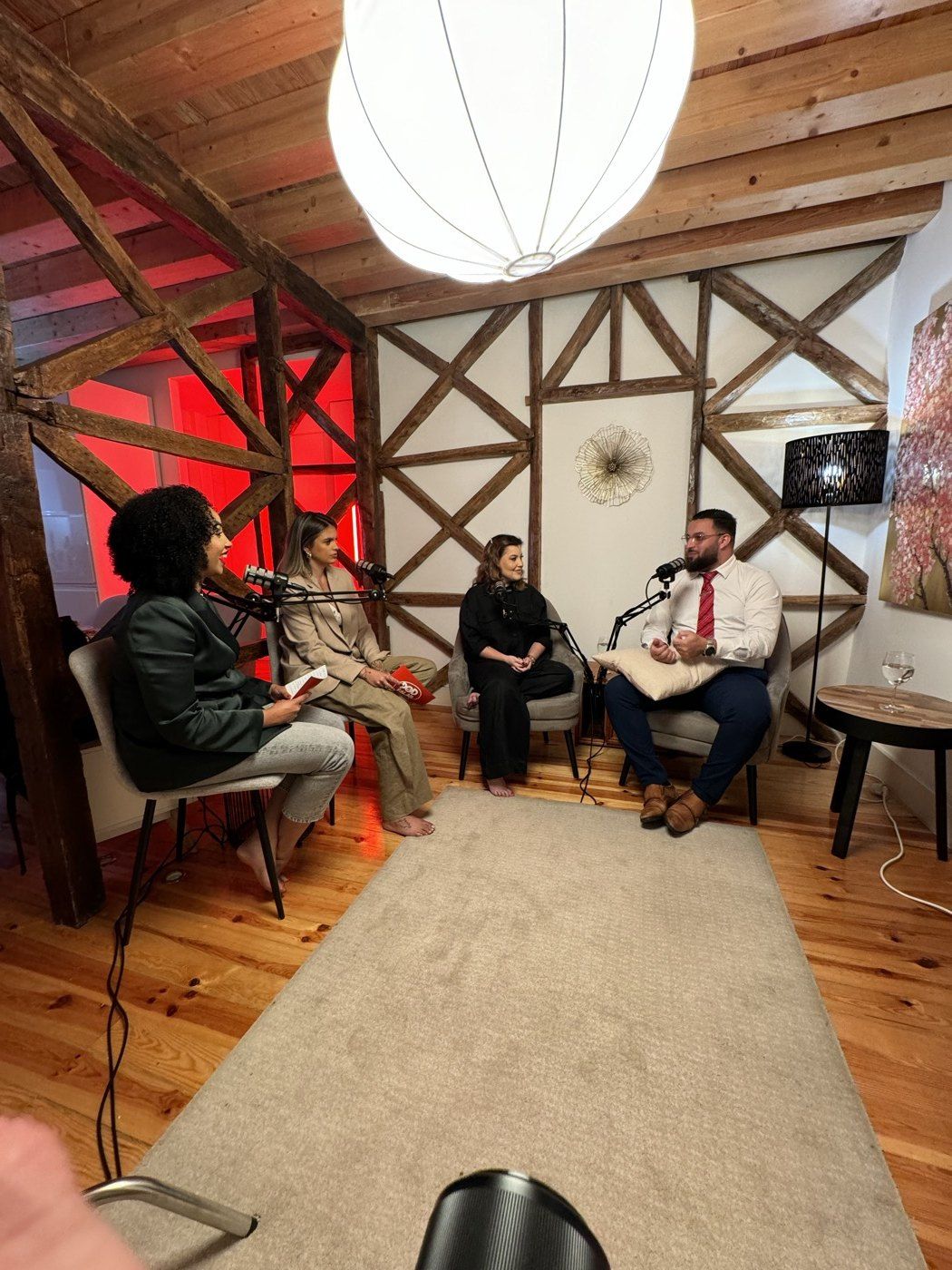 Gravação de um podcast num espaço com paredes de madeira e luz vermelha